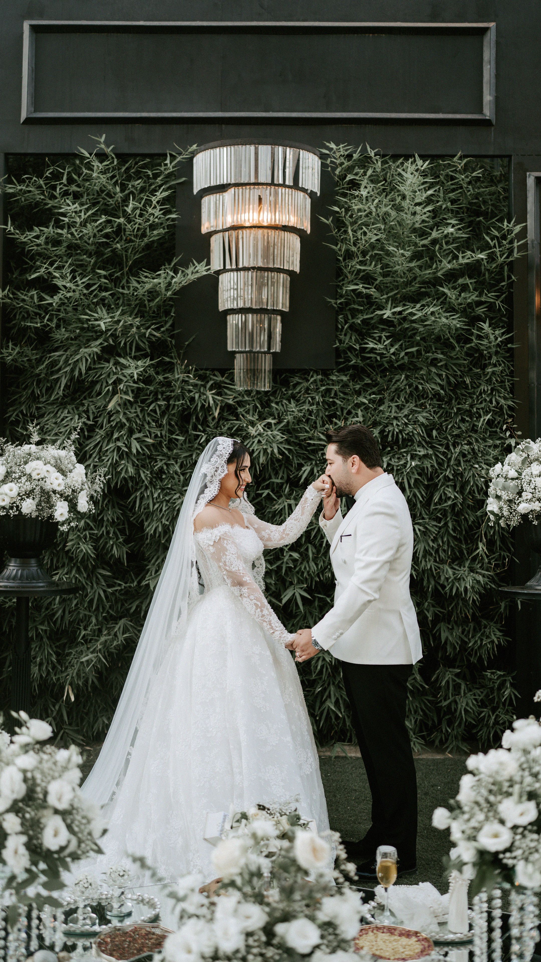 Chic wedding ceremony with bride and groom sharing a special moment in lush outdoor setting.