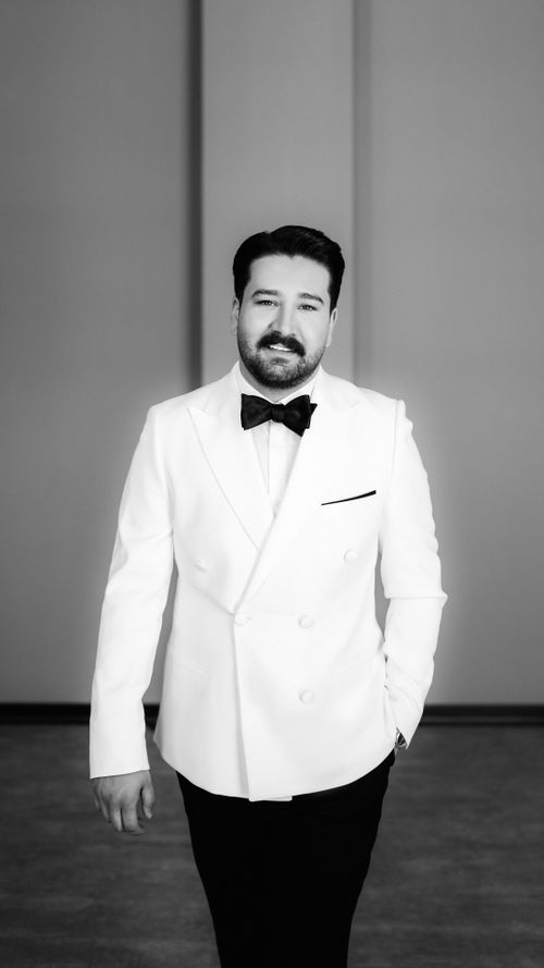 Free Black and white portrait of a groom in a classic white tuxedo. Perfect for wedding themes. Stock Photo