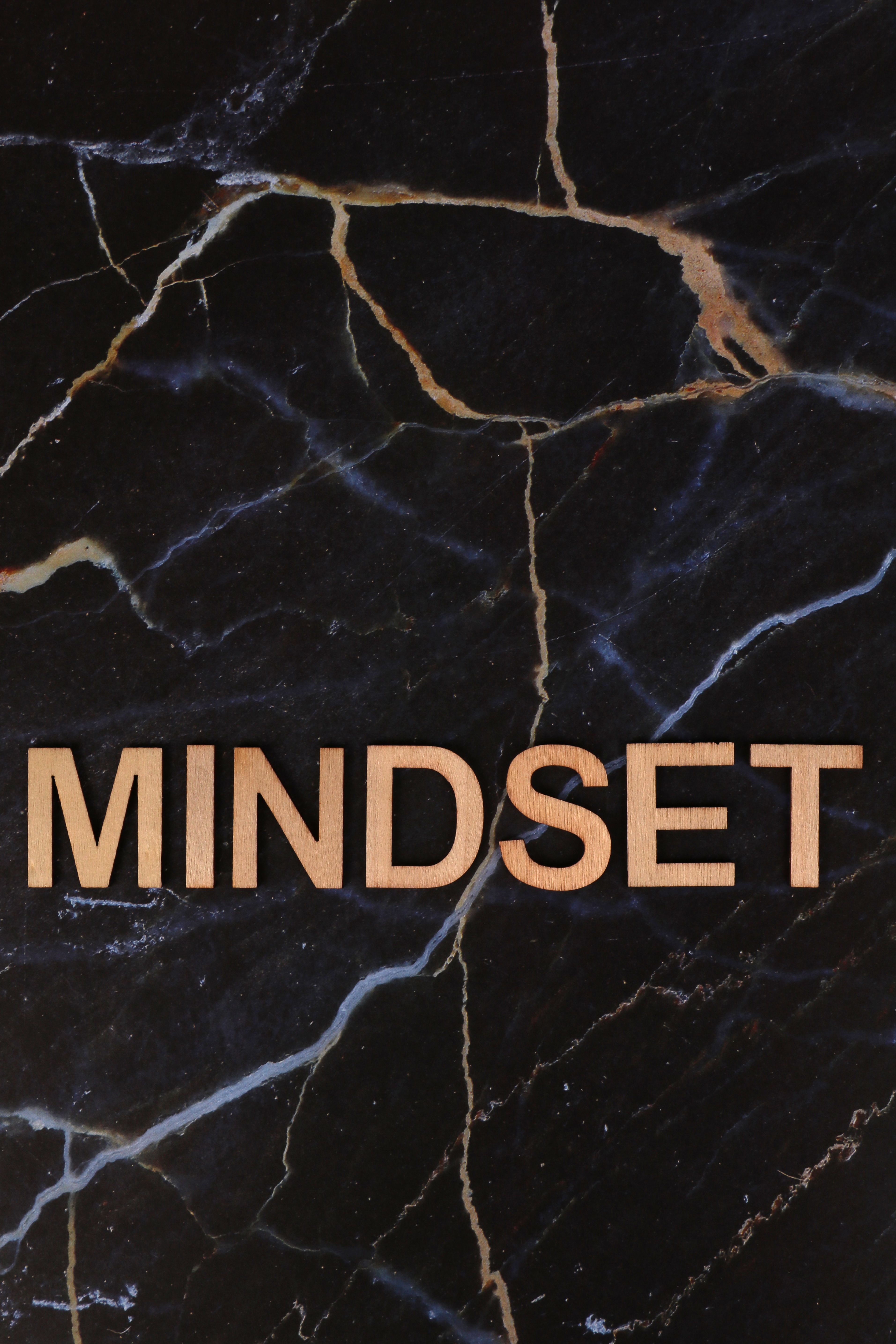 Wooden 'Mindset' text on a dark elegant marble background symbolizing modern inspiration and motivation.