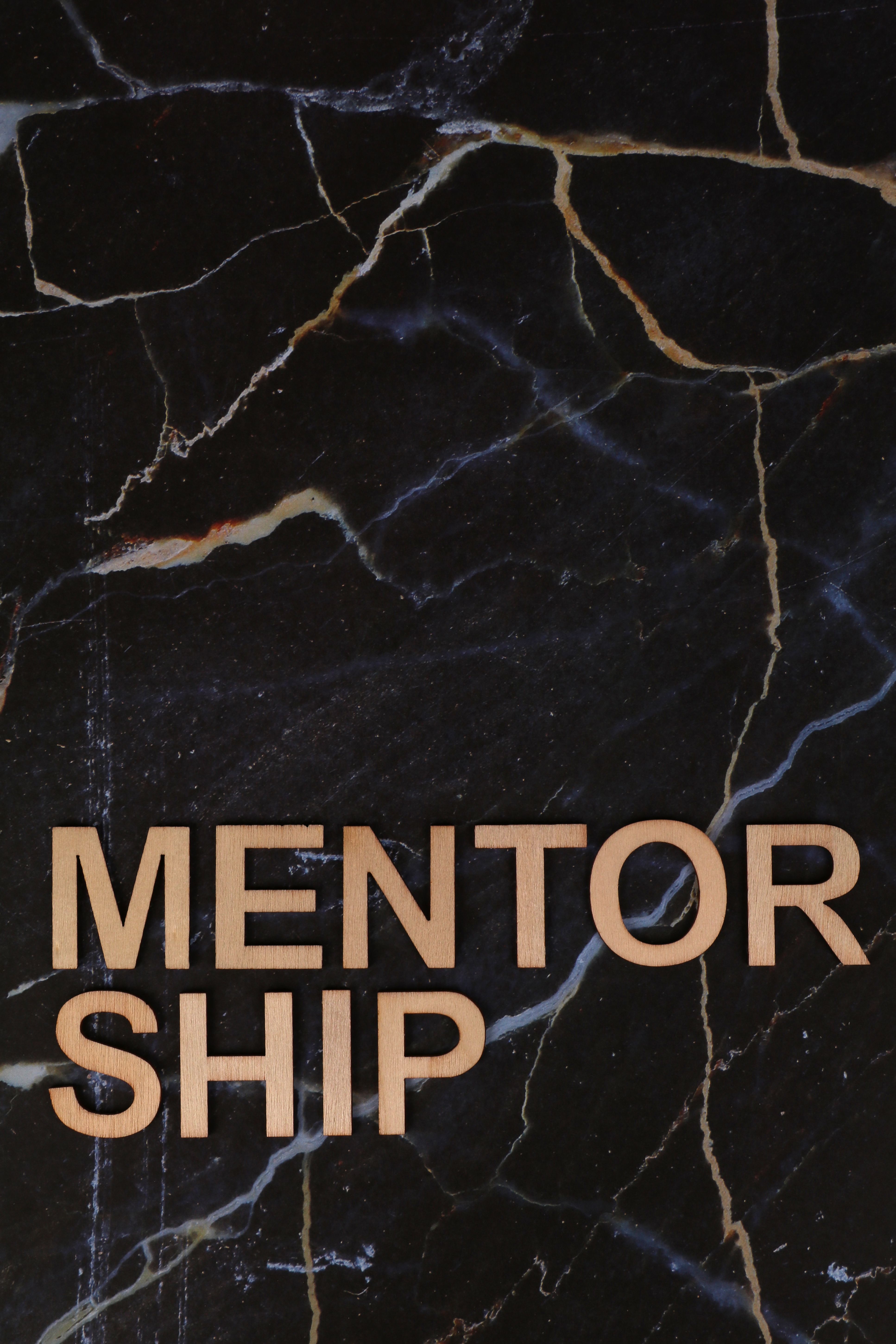 Wooden letters spelling 'MENTORSHIP' on a dark marble background, inspiring guidance and support.