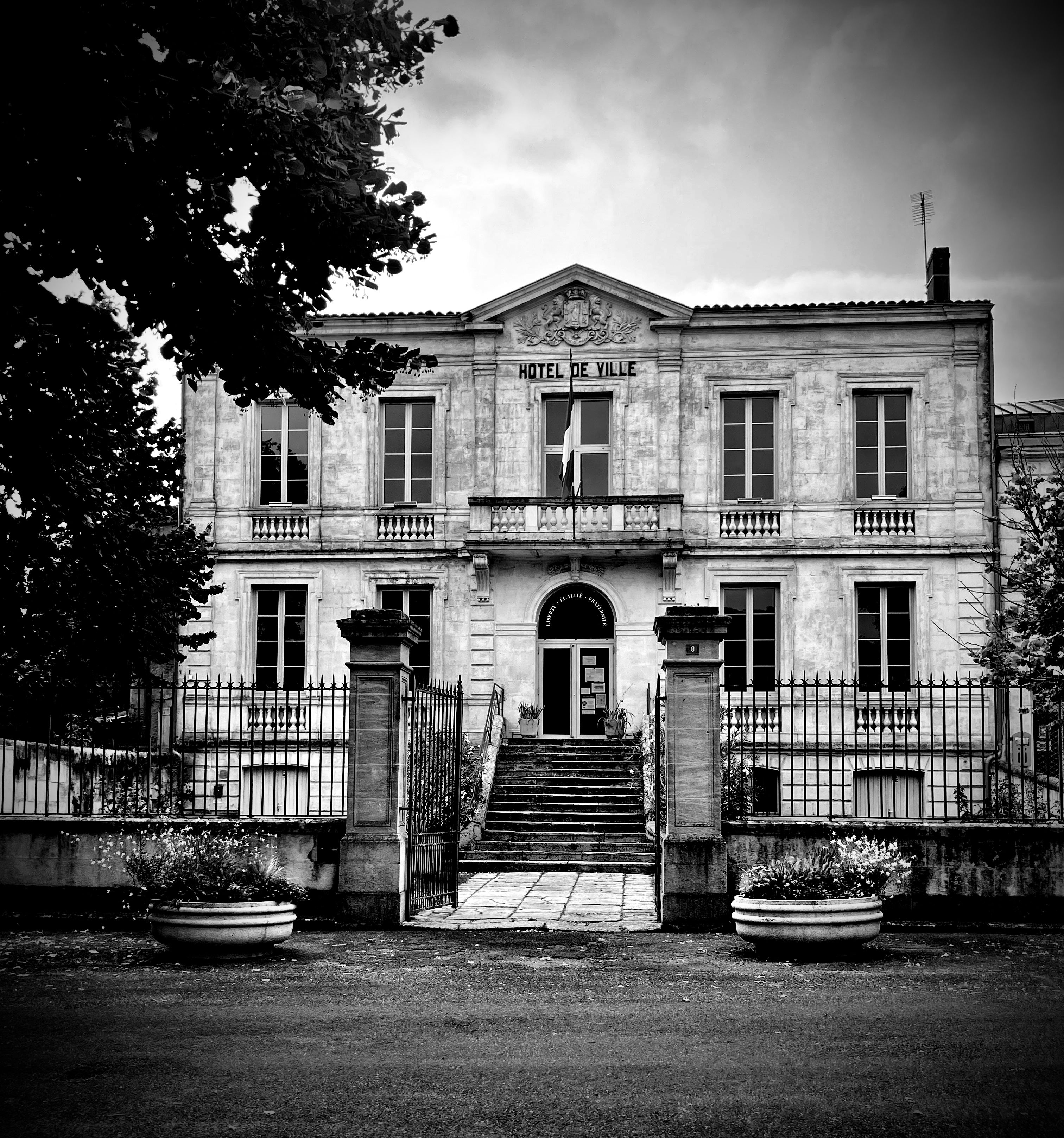 Black and white photo of the historic town hall in Saint-Macaire, France, capturing its classic architecture.
