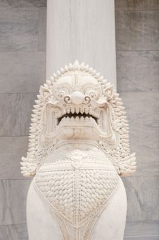 Detailed white marble statue of a mythical creature with intricate carvings, temple setting.