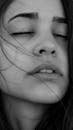 Black and white of crop young sensual female with closed eyes and long dark hair