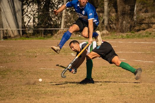 Exciting moment captured during a competitive field hockey match with players in action on the field.