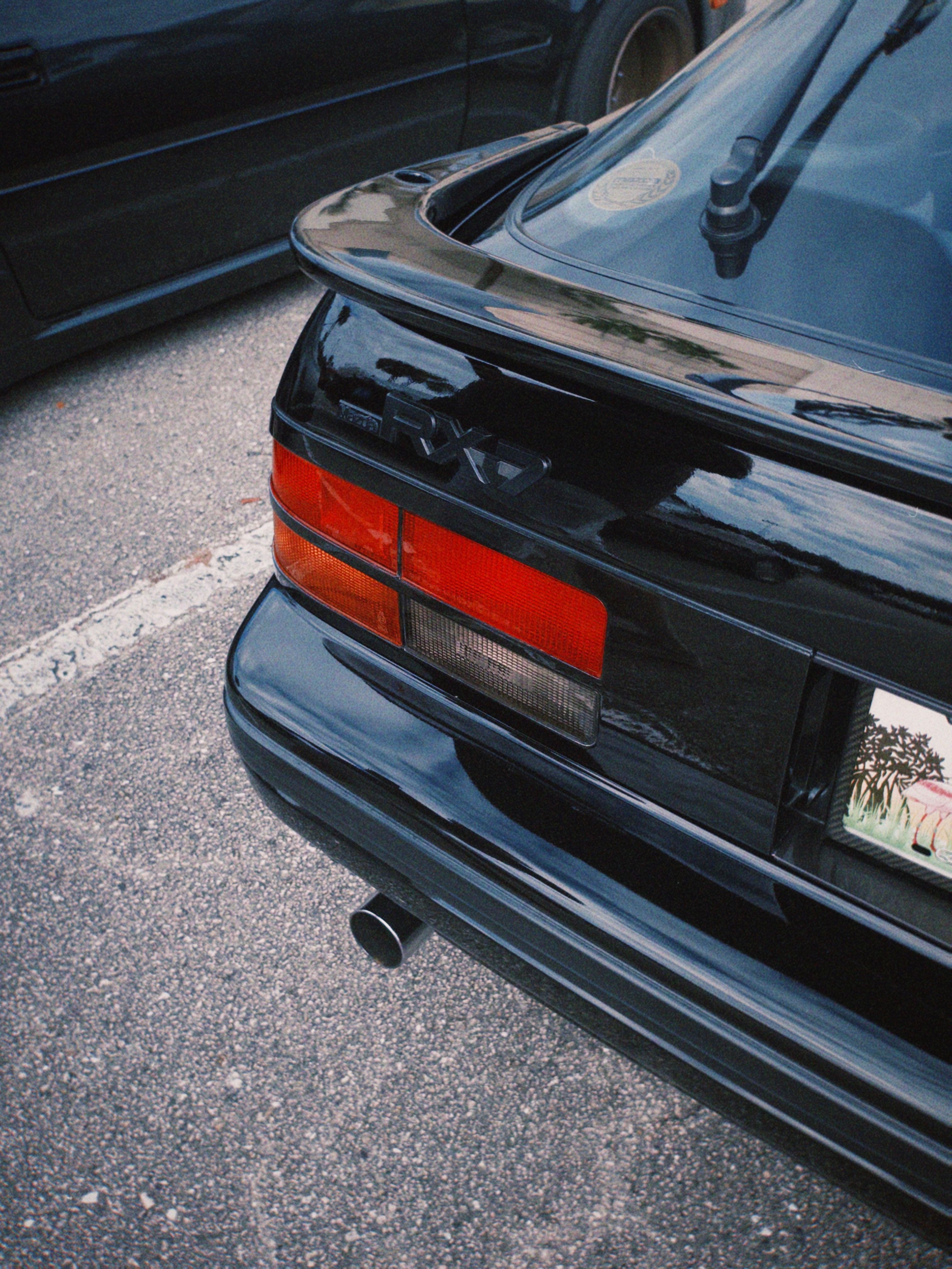 Black classic sports car parked in a West Palm Beach lot, showcasing retro automotive design.