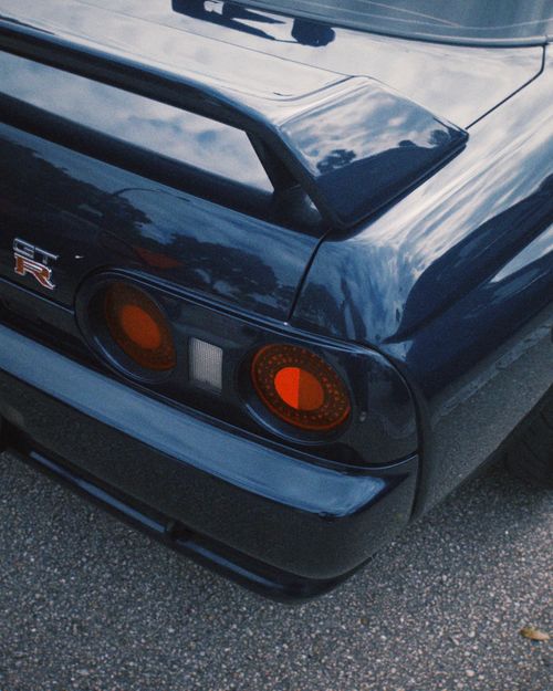 Free Close-up of a stylish blue sports car tail, showcasing sleek design and vibrant taillights. Stock Photo