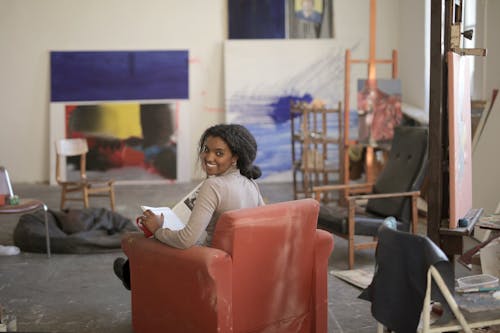 Woman In Long Sleeve Shirt Sitting On Red Chair