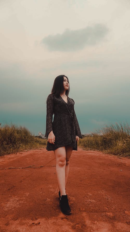 Fit ethnic woman walking on bright dry pathway in countryside