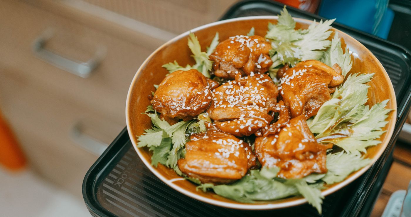 Appetizing sesame chicken bites served on fresh leafy greens, perfect for a tasty dish highlight.
