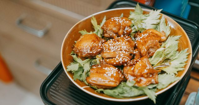 Appetizing sesame chicken bites served on fresh leafy greens, perfect for a tasty dish highlight.
