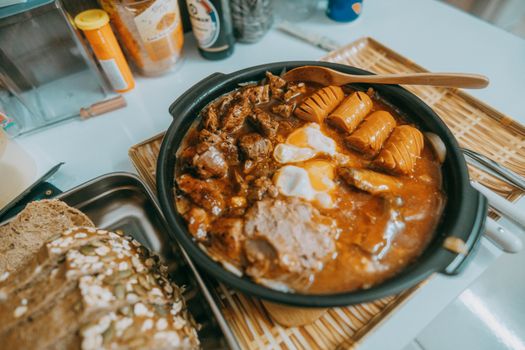 Rustic hearty stew with sausages, eggs, and dark bread. Perfect comfort food.