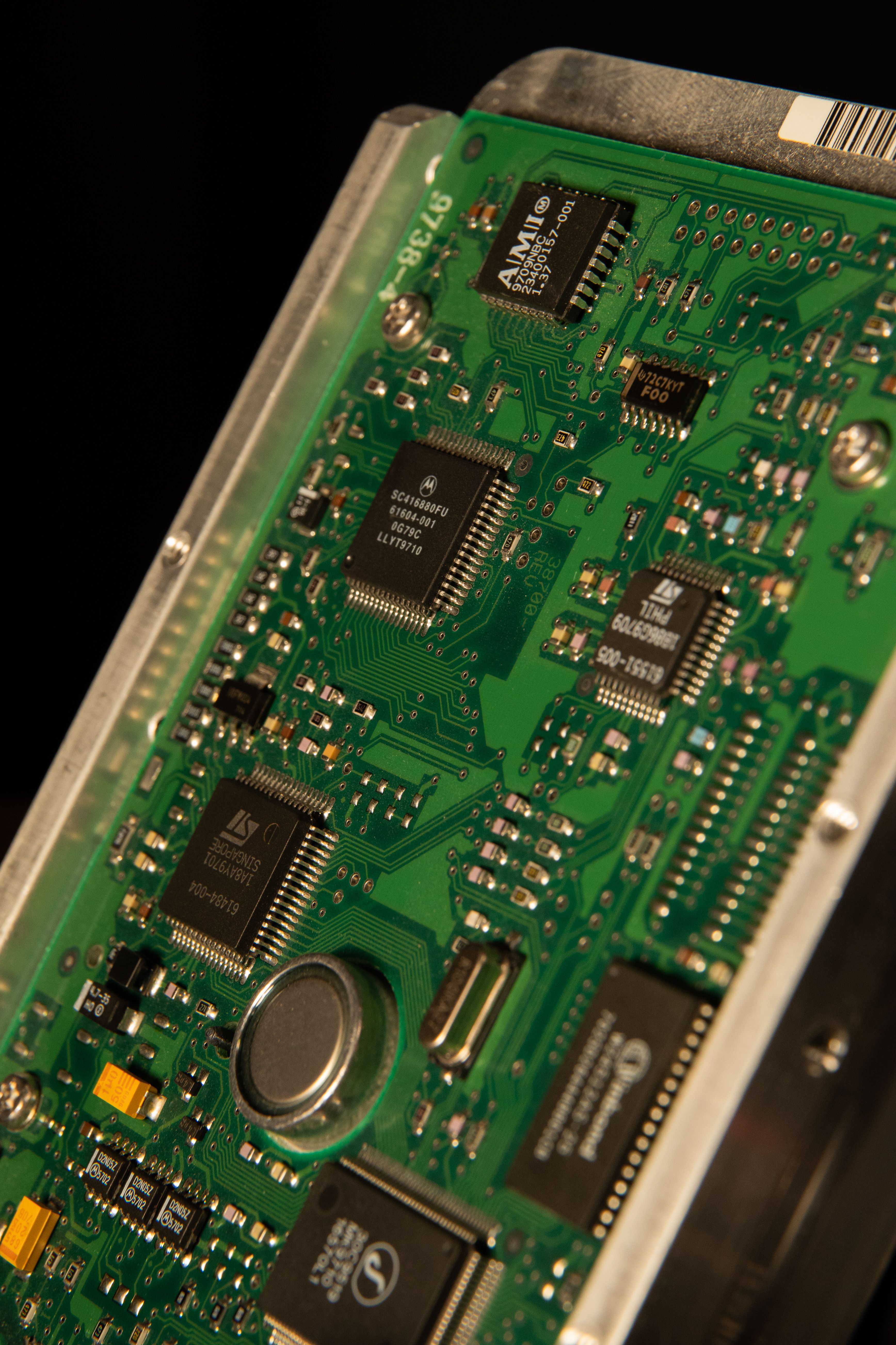 Detailed close-up of a green circuit board featuring various microchips and components.
