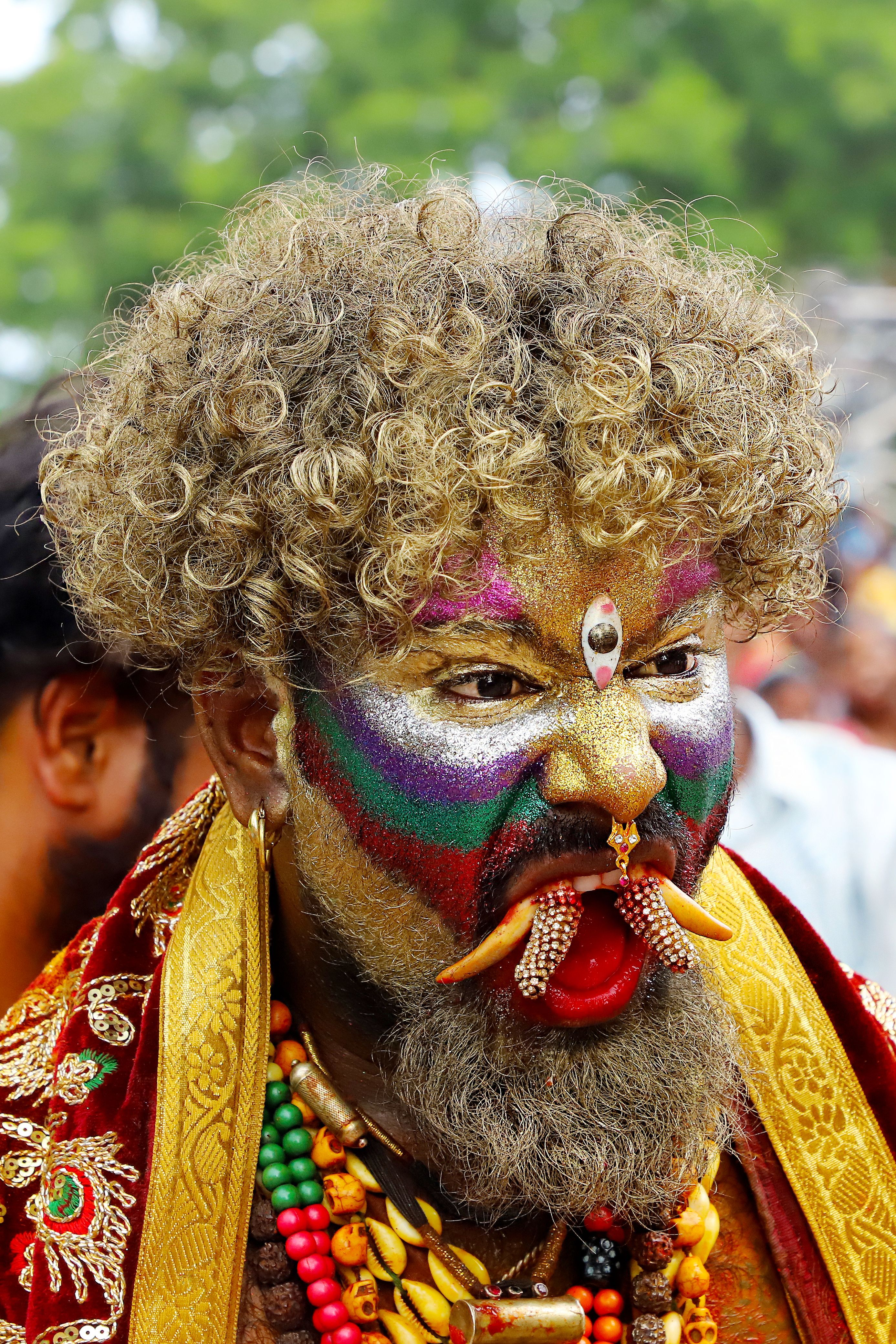 Vibrant portrait of a man with elaborate face paint at a traditional festival.