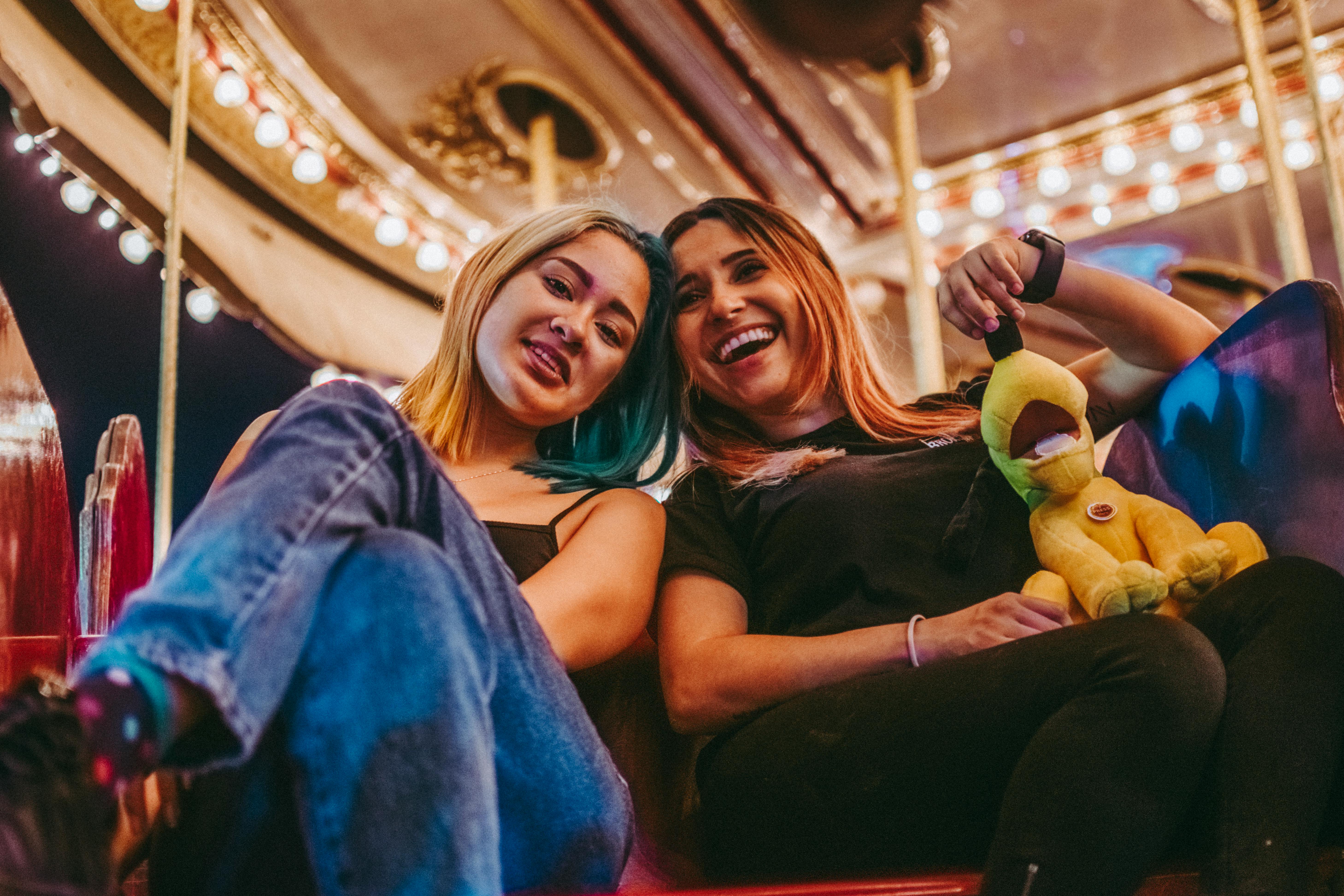 两个女人在五颜六色的游乐园里一起欢笑，分享着快乐的时光