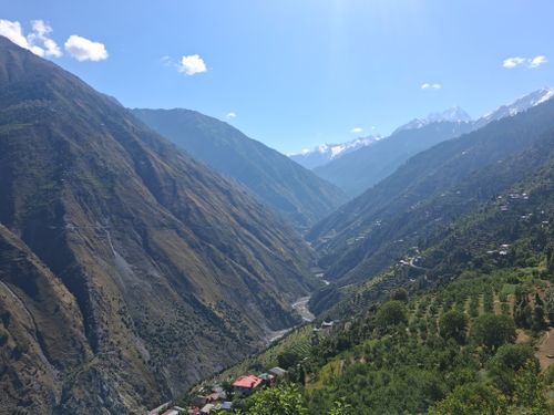 Free A breathtaking view of a lush green valley in the Himalayan mountains under a clear blue sky. Stock Photo