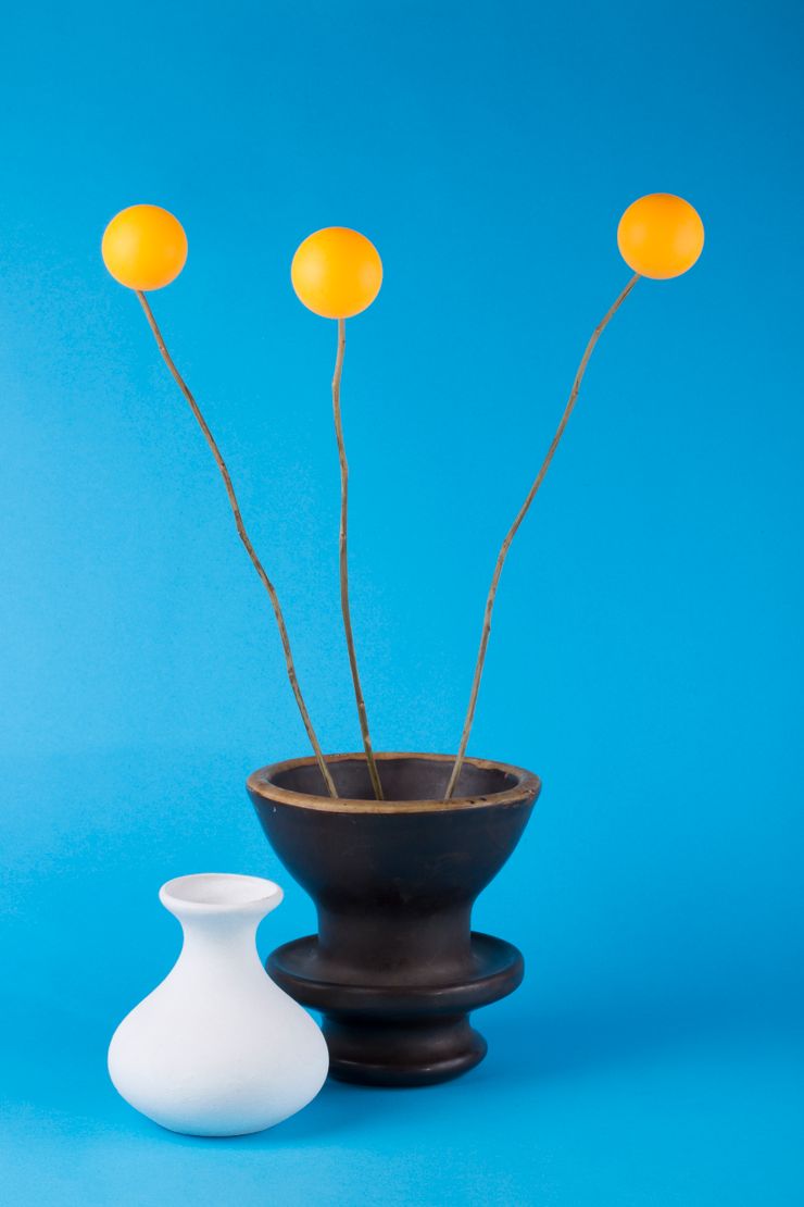 Two ceramic vases with dried craspedia stems against a blue backdrop — photo by Valentin Ivantsov on Pexels