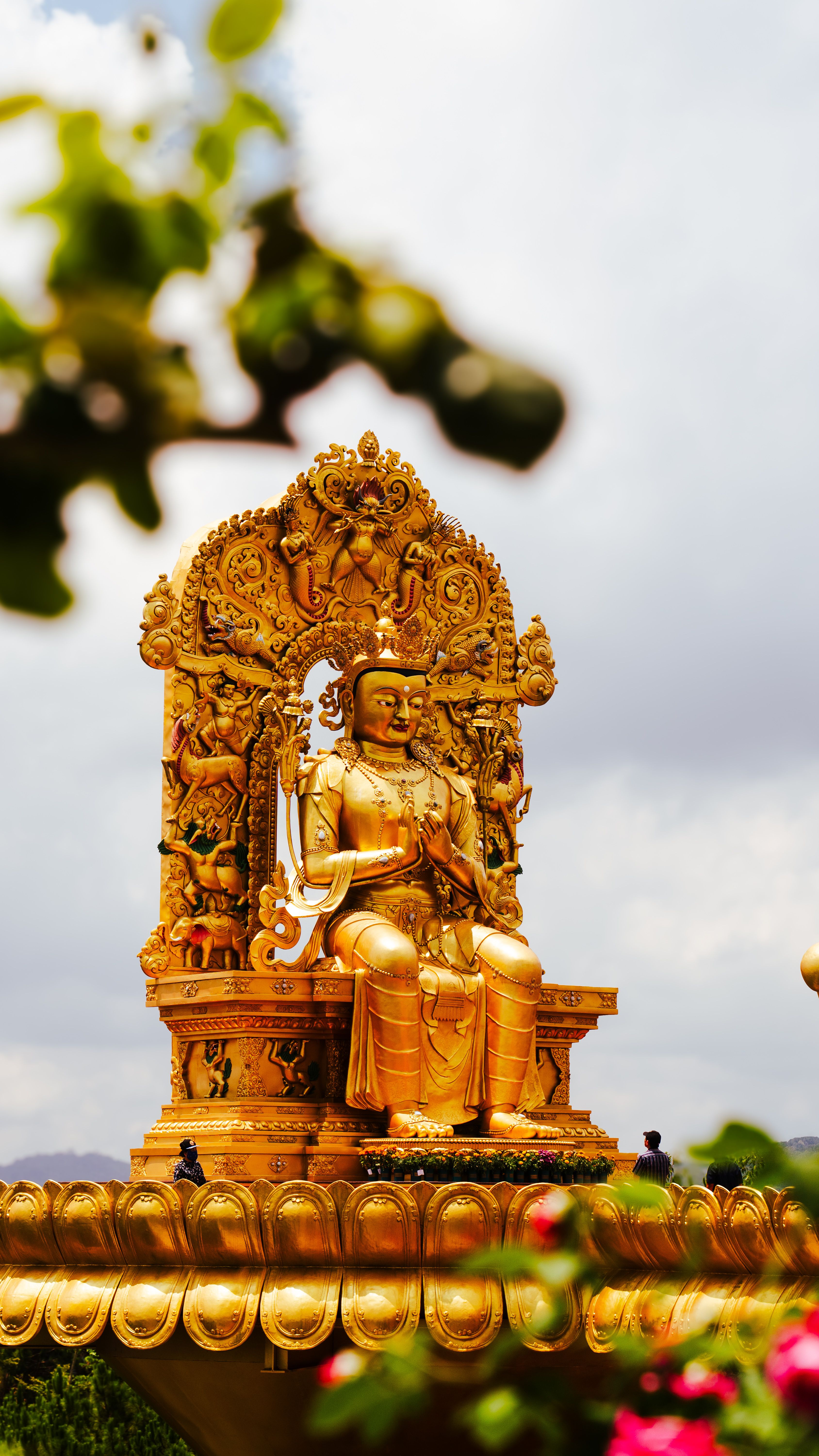 Majestic golden Buddha statue under the cloudy sky in Da Lat, Vietnam.