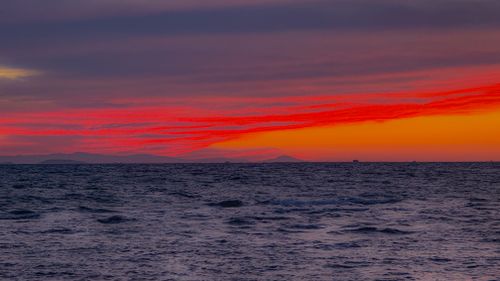 Free Experience a breathtaking sunset over a tranquil ocean with vivid red and orange skies. Stock Photo
