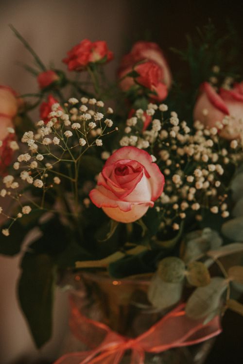 Free Beautiful close-up of pink roses with baby's breath, elegantly arranged in a vase. Stock Photo