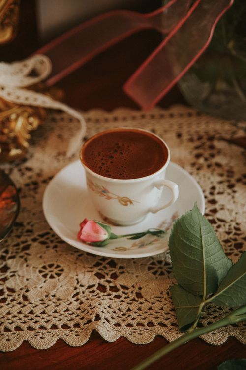 Free A delicate cup of Turkish coffee on a lace tablecloth with a pink rose. Stock Photo