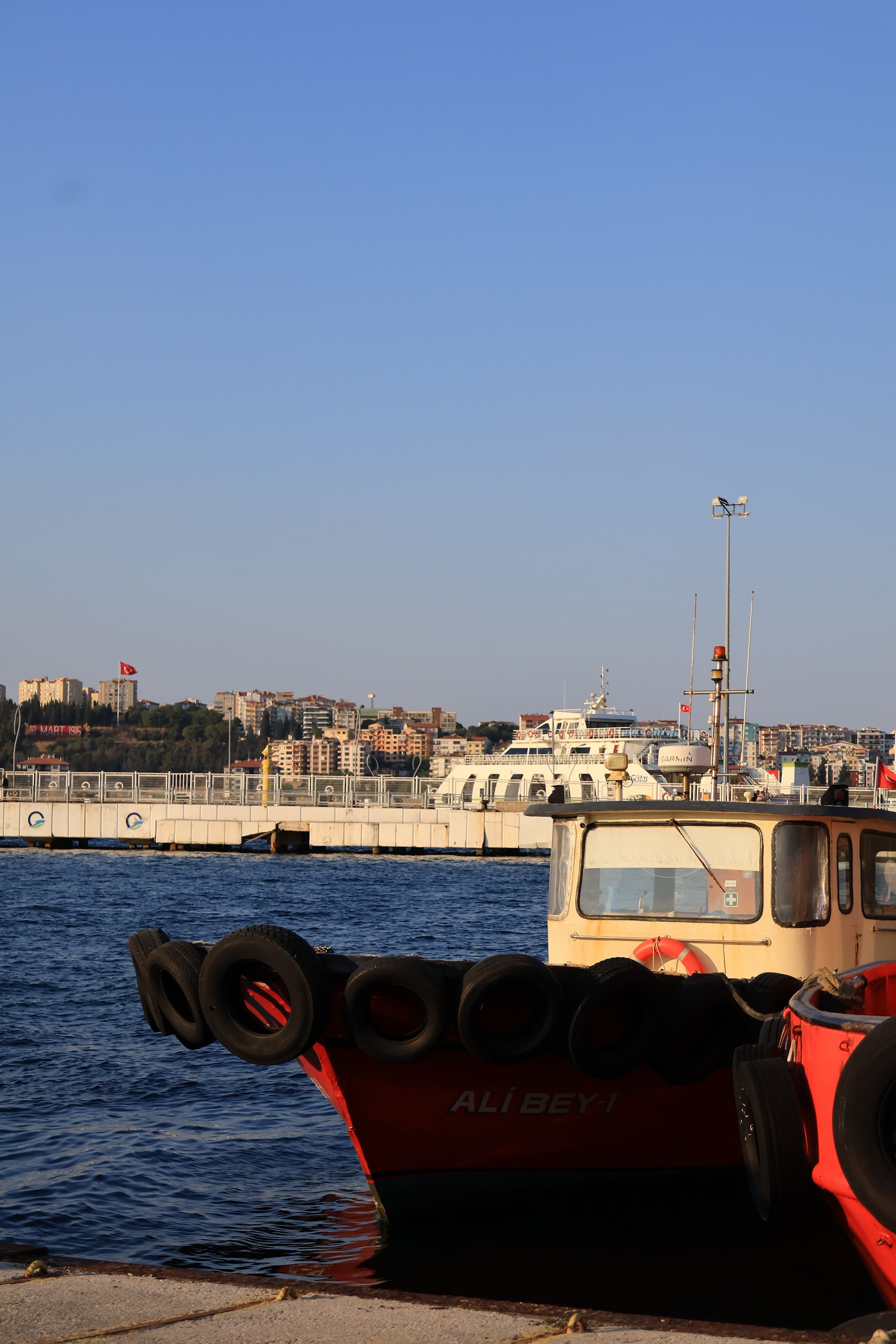 View of boats at the dock with a cityscape backdrop in Çanakkale, Türkiye.