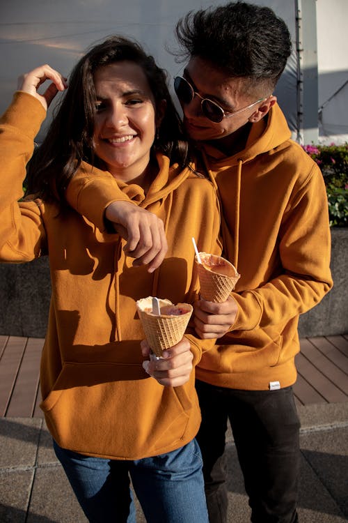 Man And Woman In Orange Hoodie Holding Ice Cream Cone