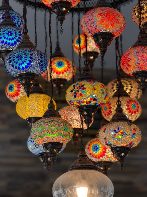 Free A vibrant collection of Turkish mosaic lamps with intricate glass patterns hanging indoors. Stock Photo