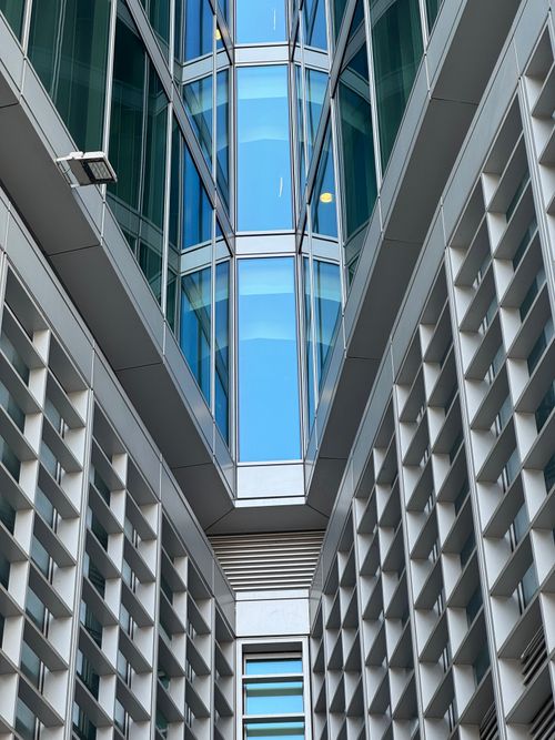 Free Symmetrical view of modern glass and concrete architecture in Milan, Italy capturing geometric lines and reflections. Stock Photo