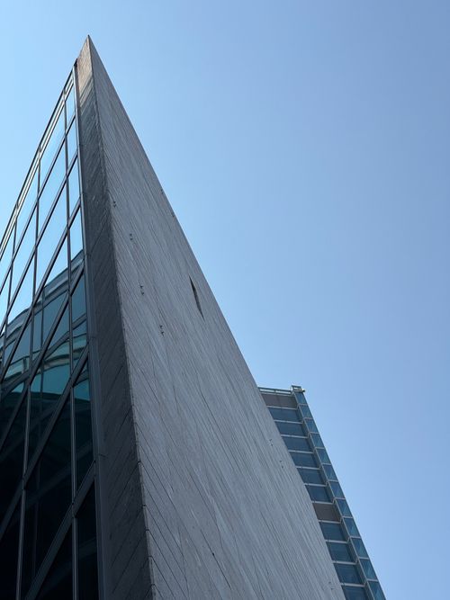 Free A striking modern building in Milan with a sharp angle against a clear blue sky. Stock Photo