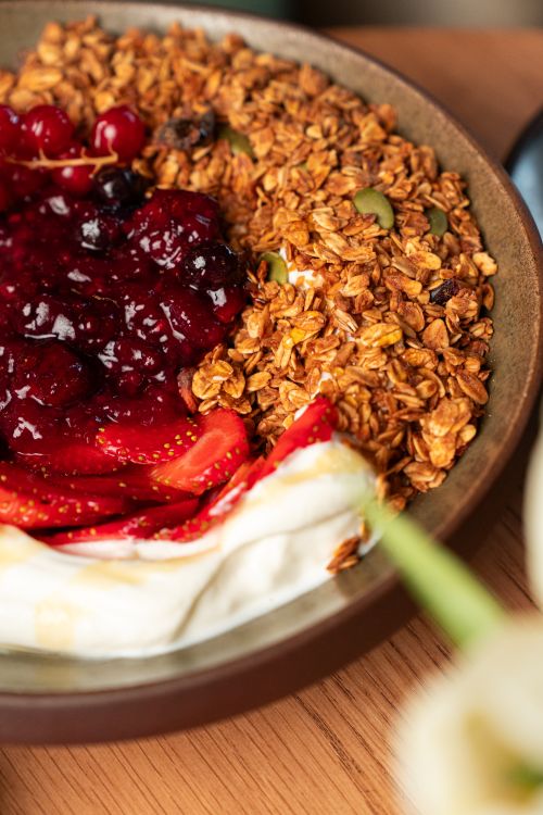 Free Top view of a yogurt breakfast bowl with granola, fresh strawberries, and berry compote. Stock Photo