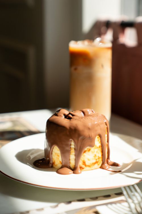 Free Cheesecake drizzled with chocolate alongside a refreshing iced coffee. Stock Photo