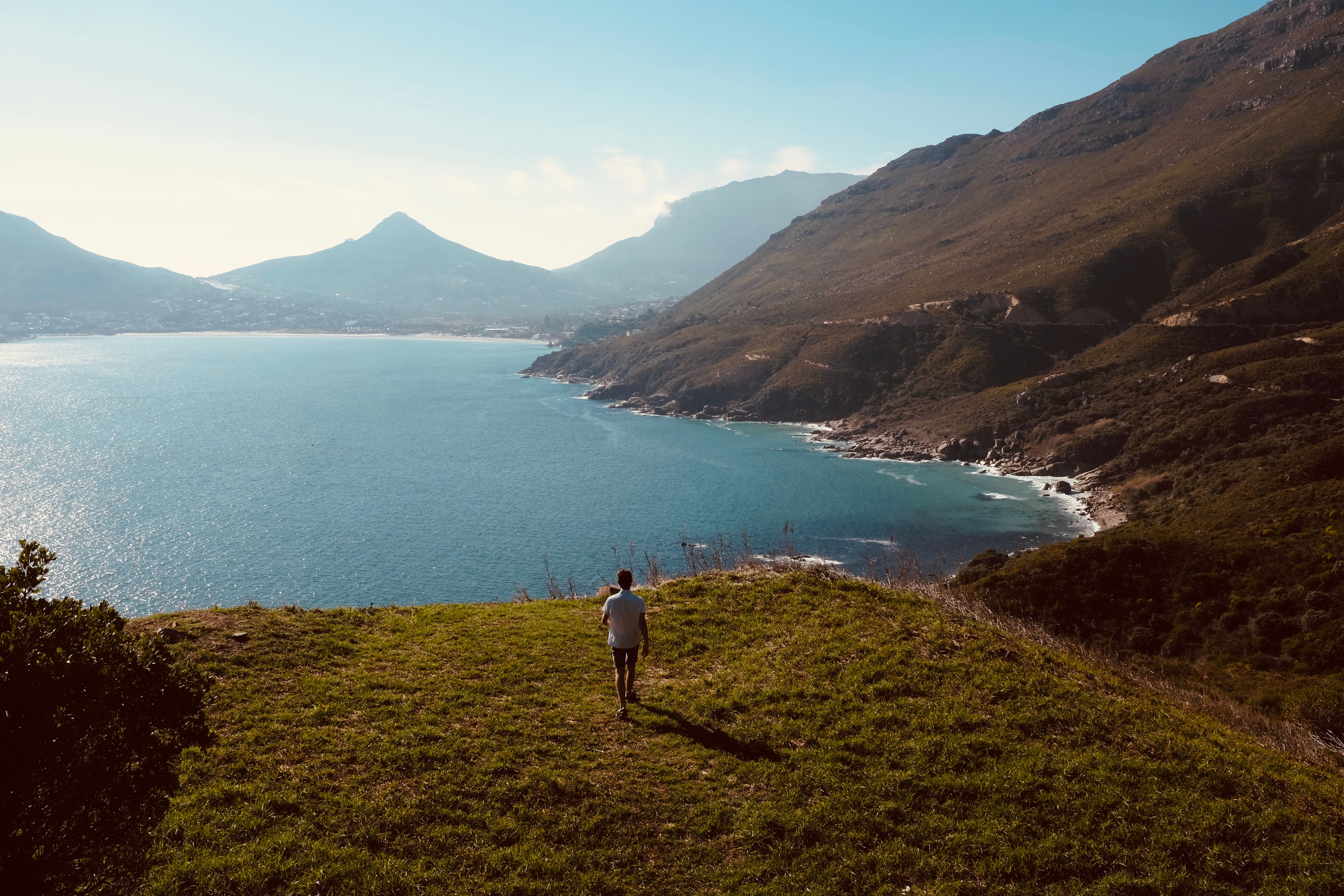 A serene coastal scene in Cape Town showcasing mountains and the expansive ocean under a clear sky.
