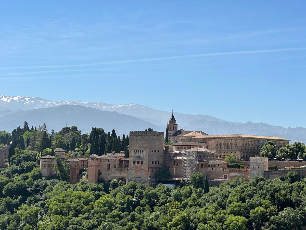 Palatul Alhambra din Granada cu munții Sierra Nevada înzăpeziți în fundal