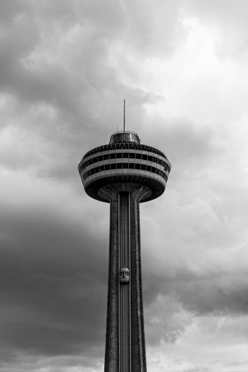 Free Black and white photo of Skylon Tower under a dramatic cloudy sky in Niagara Falls, Ontario. Stock Photo