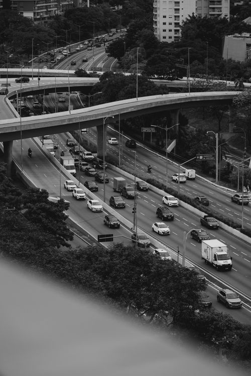 Free Aerial view of bustling urban highway with layered overpasses and dense traffic. Stock Photo