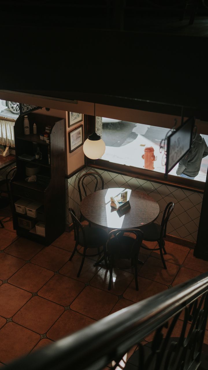 tiny round bistro table in a home corner used as a small coffee bar with a stool