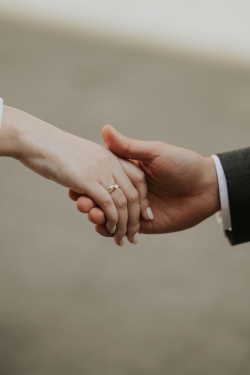 Free Close-up of a couple holding hands showcasing wedding rings, symbolizing love and commitment. Stock Photo