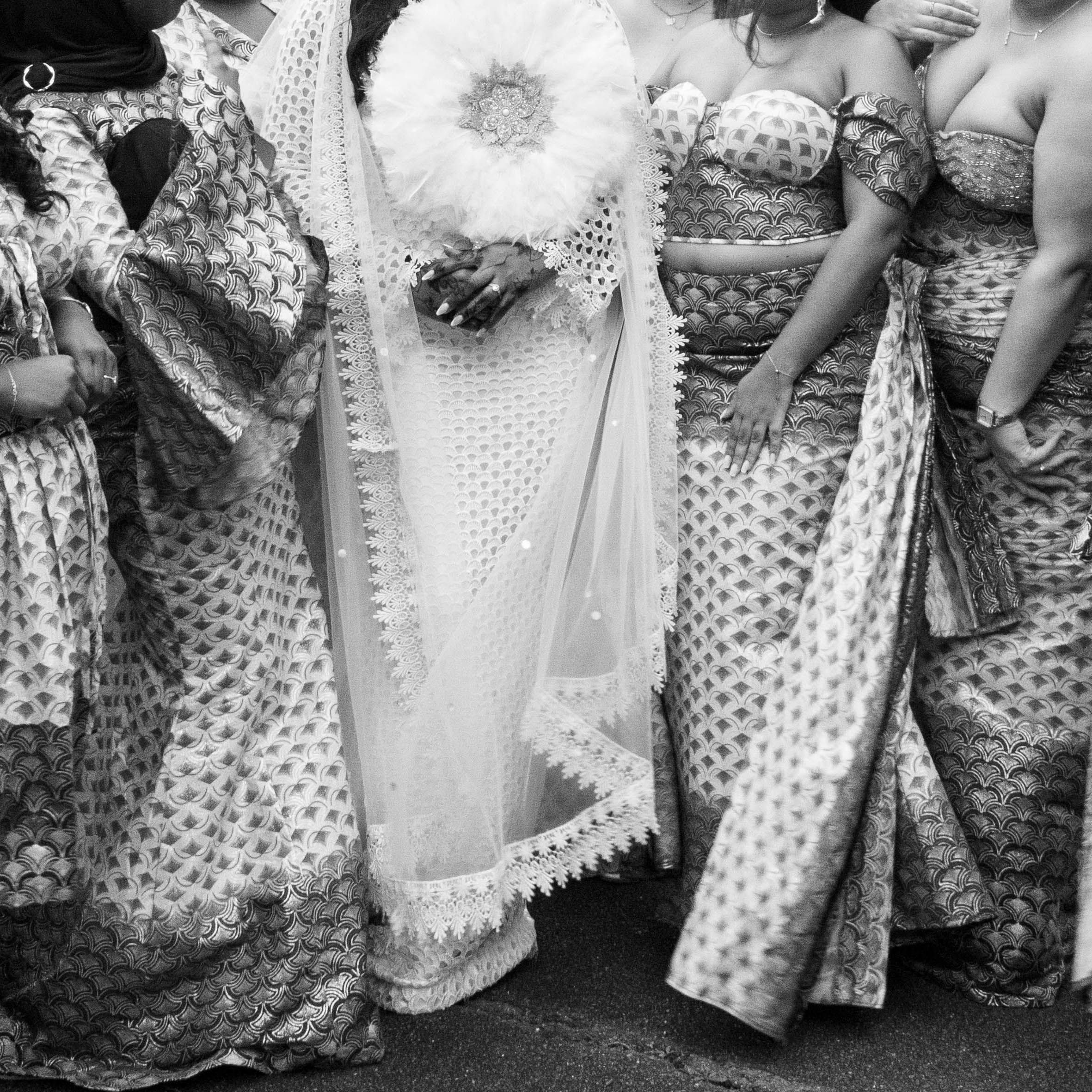A group photo of women in traditional attire, highlighting a bride with a bouquet.