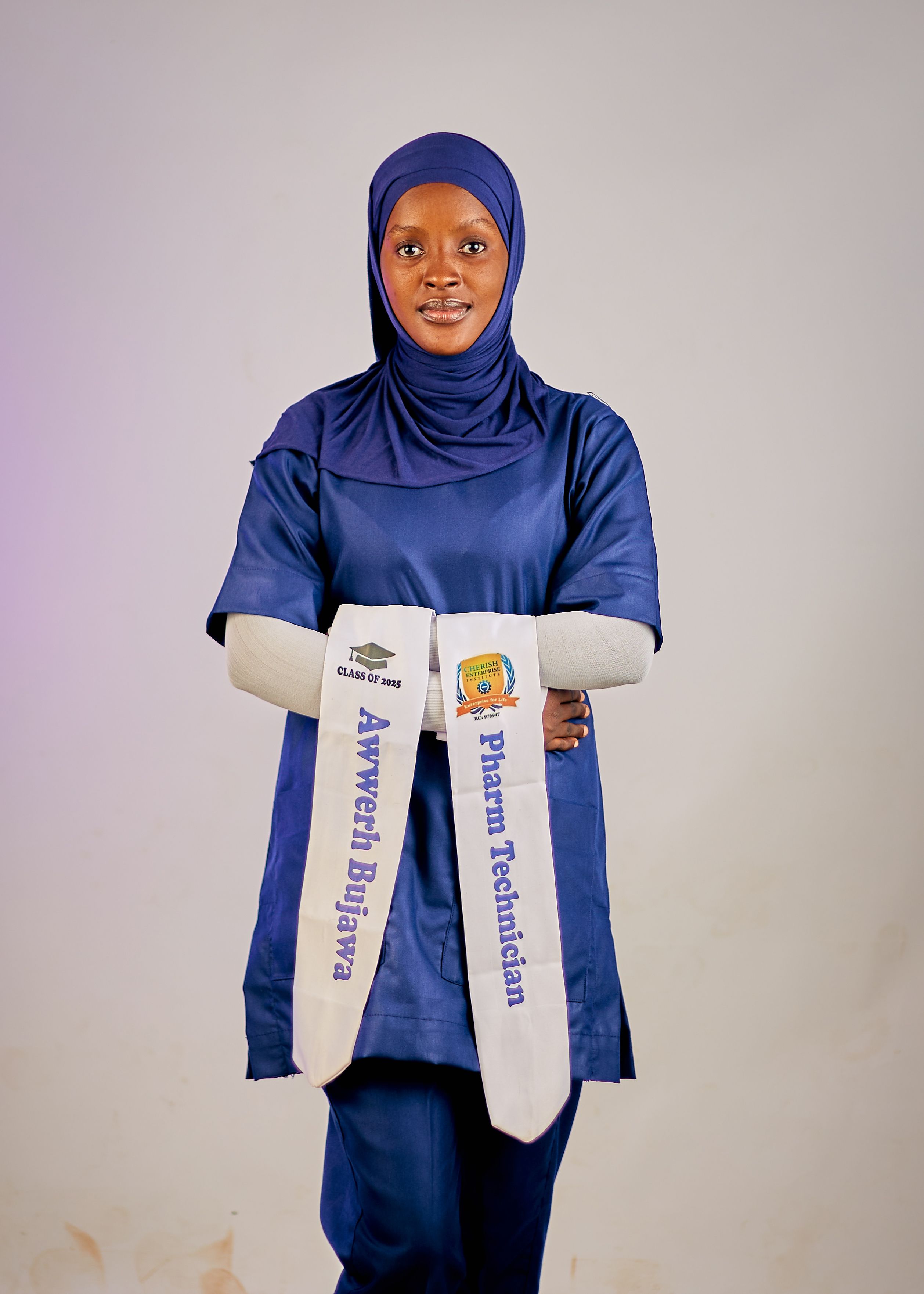 Muslim woman in graduation attire for pharmacy technician program.