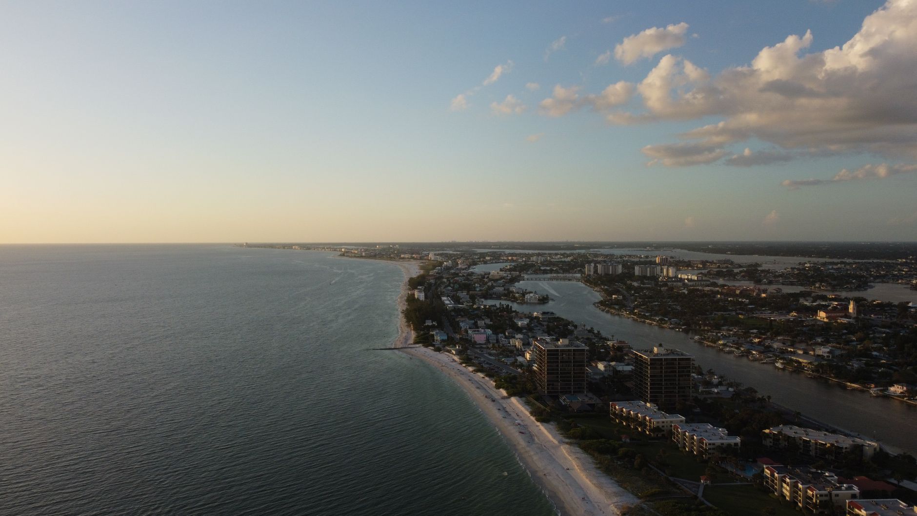 Door hanger delivery in Naples, FL Door hanger distribution and flyer delivery in Naples, FL — Dramatic aerial view of a coastal city with stunning sunset lighting and expansive ocean vistas. above neighborhoods DoorBlitz crews walk