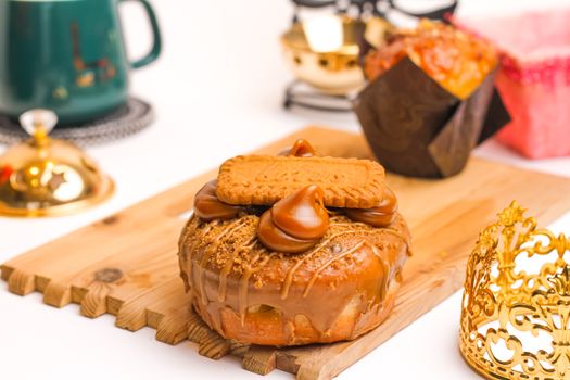Close-up of a Biscoff donut topped with caramel and surrounded by elegant tableware, perfect for gourmet breakfast ideas.