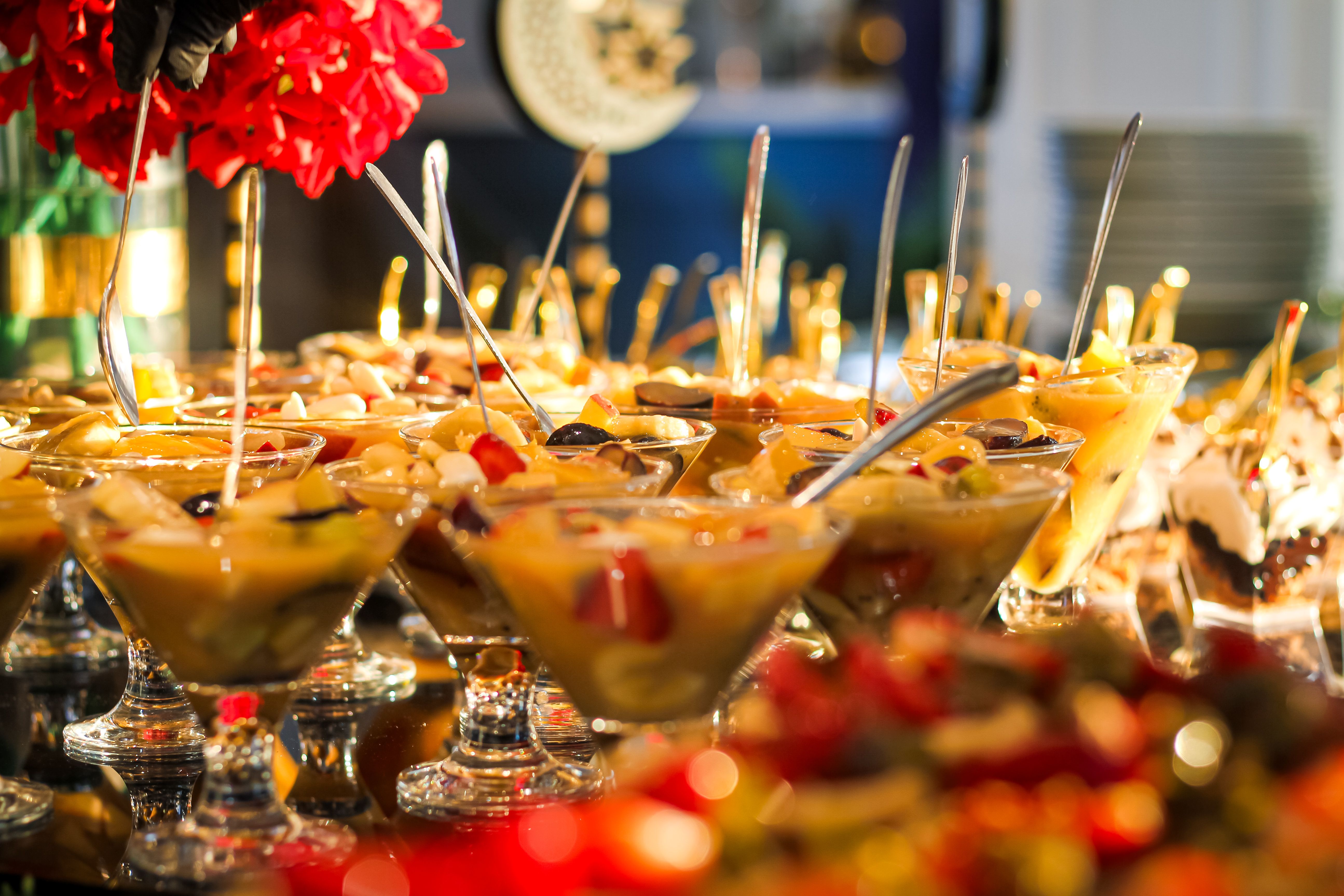 Colorful fruit cocktail buffet with elegant glass presentation at an event.