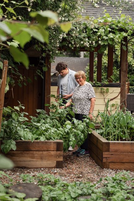 Photo by Jelly Marketing on Pexels Multigenerational family bonding while gardening in a lush, vibrant backyard.