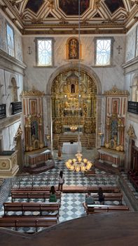 Beautiful historic church interior in Salvador, Brazil, showcasing ornate baroque architecture with visitors.