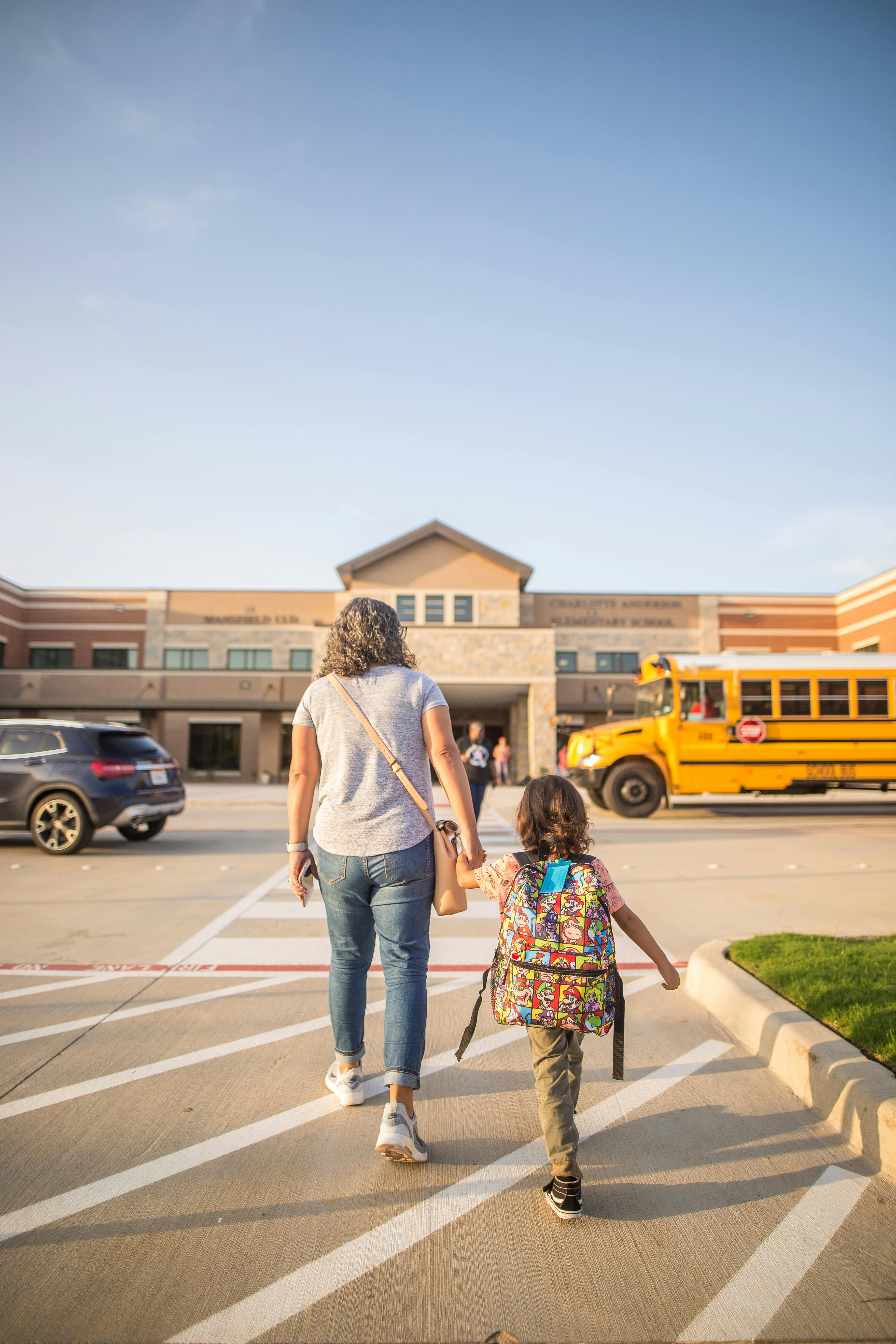 Free Anonymous mother leading daughter to school in city Stock Photo