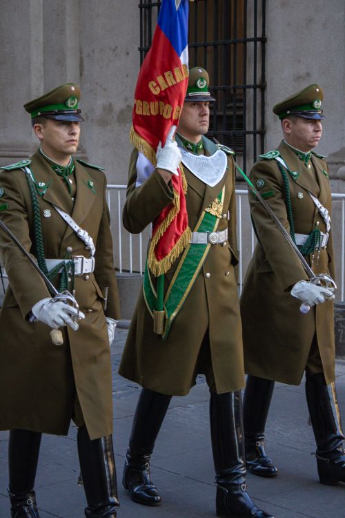 Free Three uniformed Carabineros march during a parade in Santiago, Chile, showcasing national pride. Stock Photo
