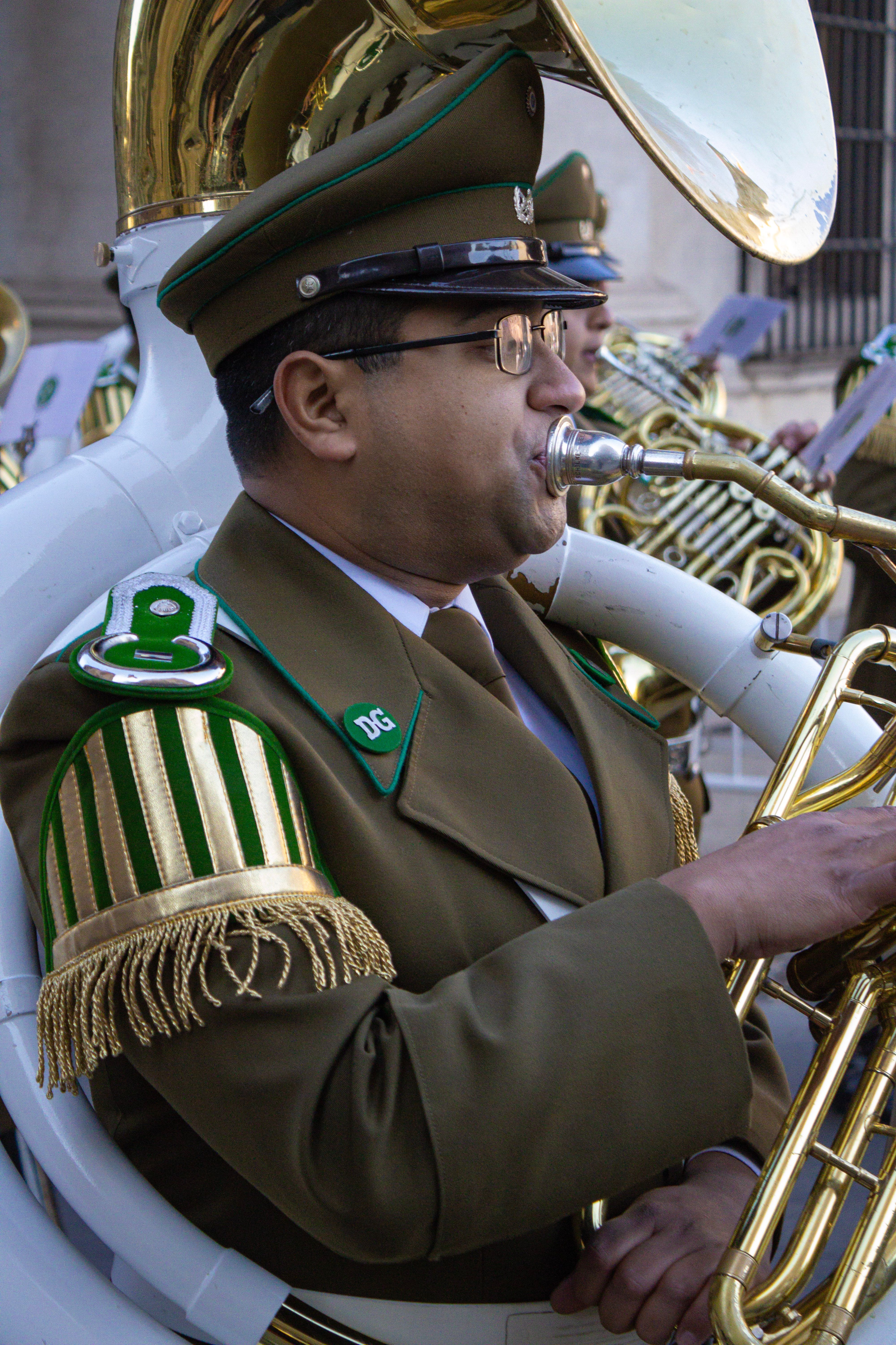 A uniformed military band member performs with a tuba during a parade in Santiago, Chile.