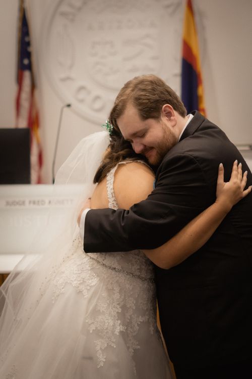 Free A bride and groom share a touching embrace in a courthouse after their wedding ceremony. Stock Photo