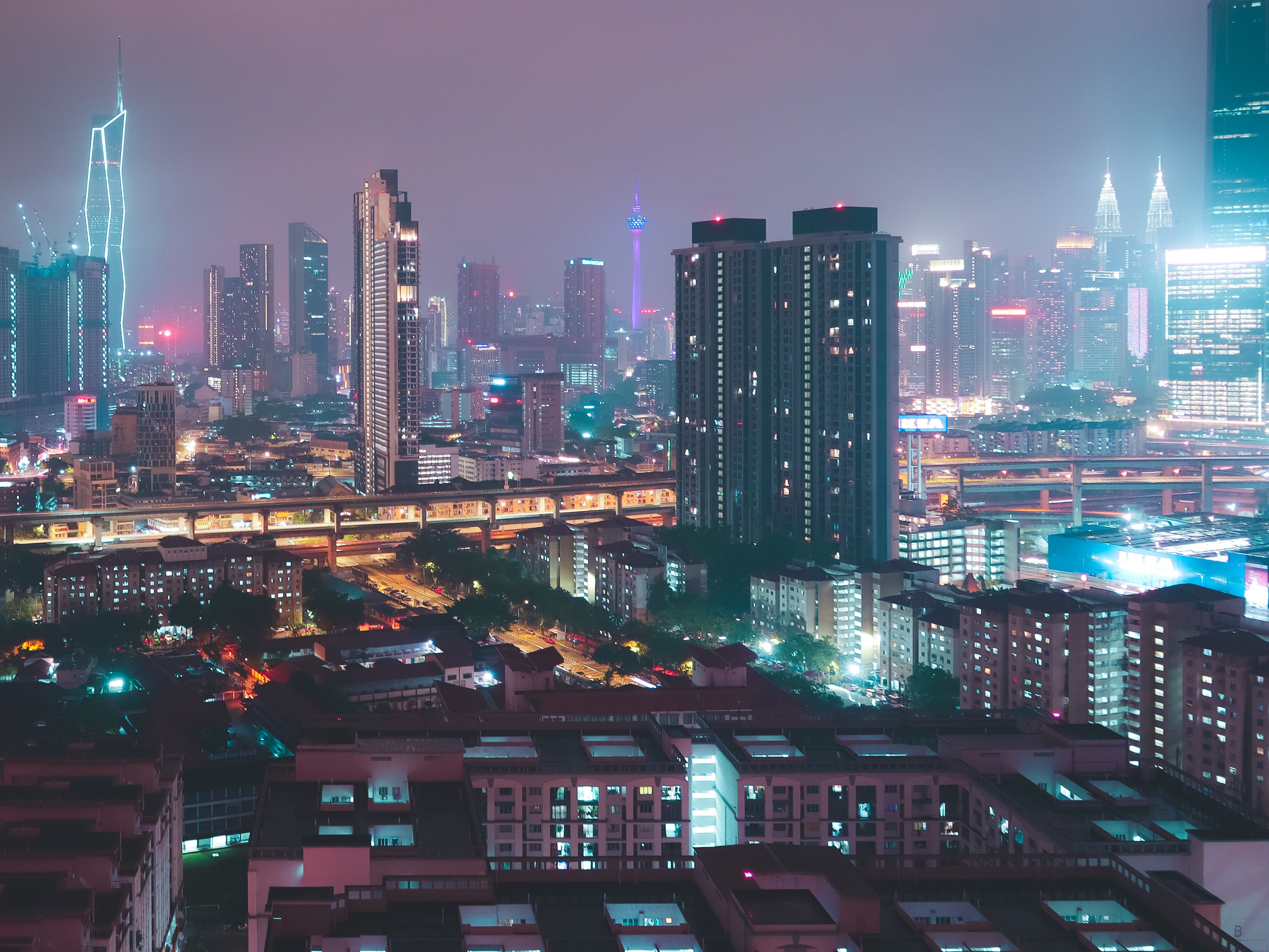 Explore the illuminated skyline of Kuala Lumpur, showcasing iconic skyscrapers and vibrant city lights.