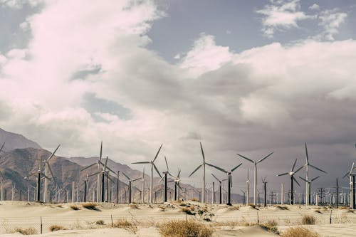 Free Wind Turbines On Sand Under White Cloudy Sky Stock Photo